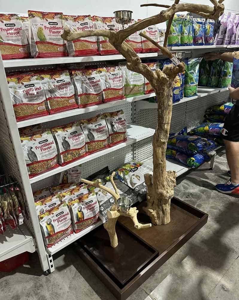 A Wooden Bird Stand With Branches, Set in a Pet Supply Store, Near Food Bags — Jonath’s Animal Kingdom in Beresfield, NSW