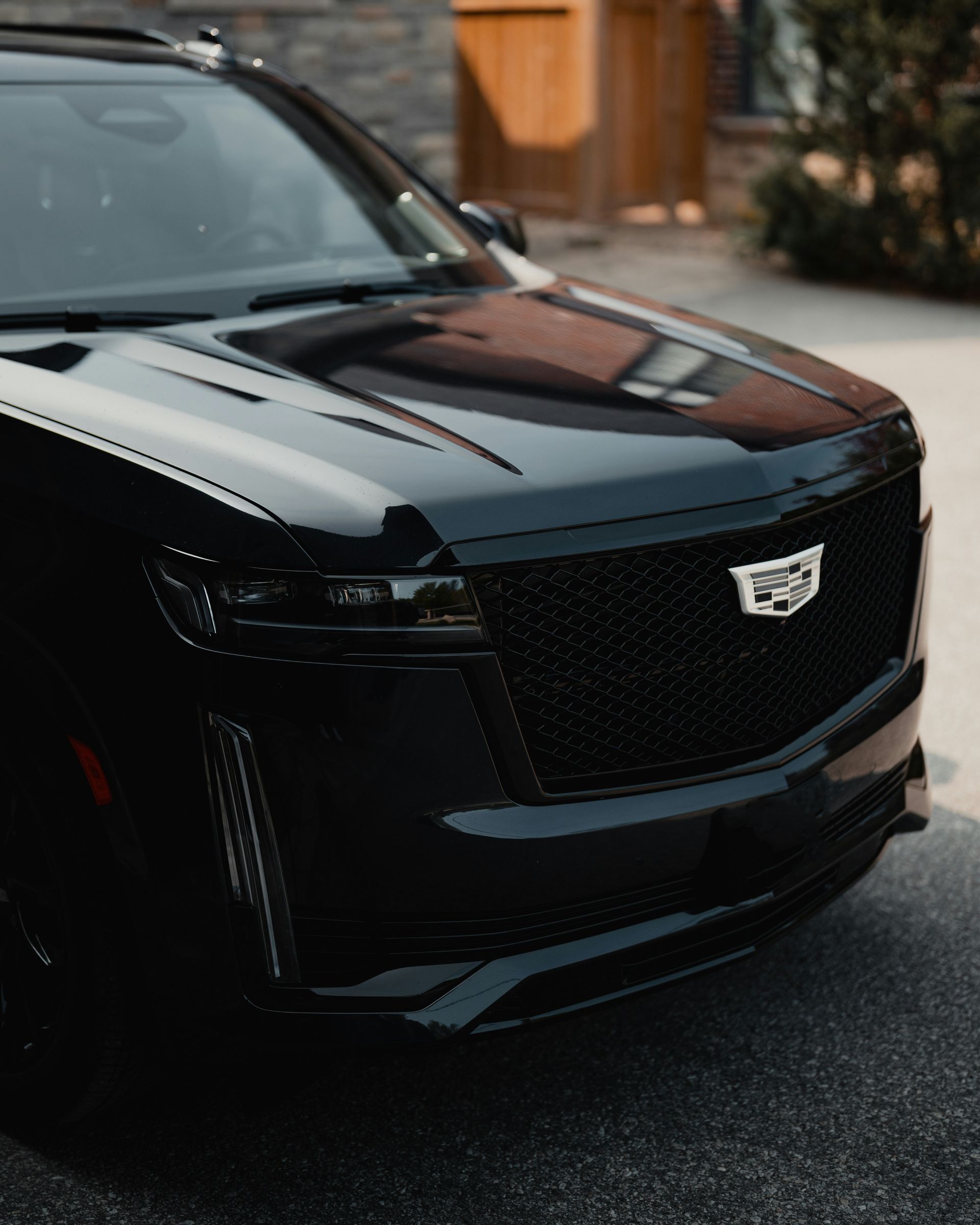 A black cadillac is parked on the side of the road