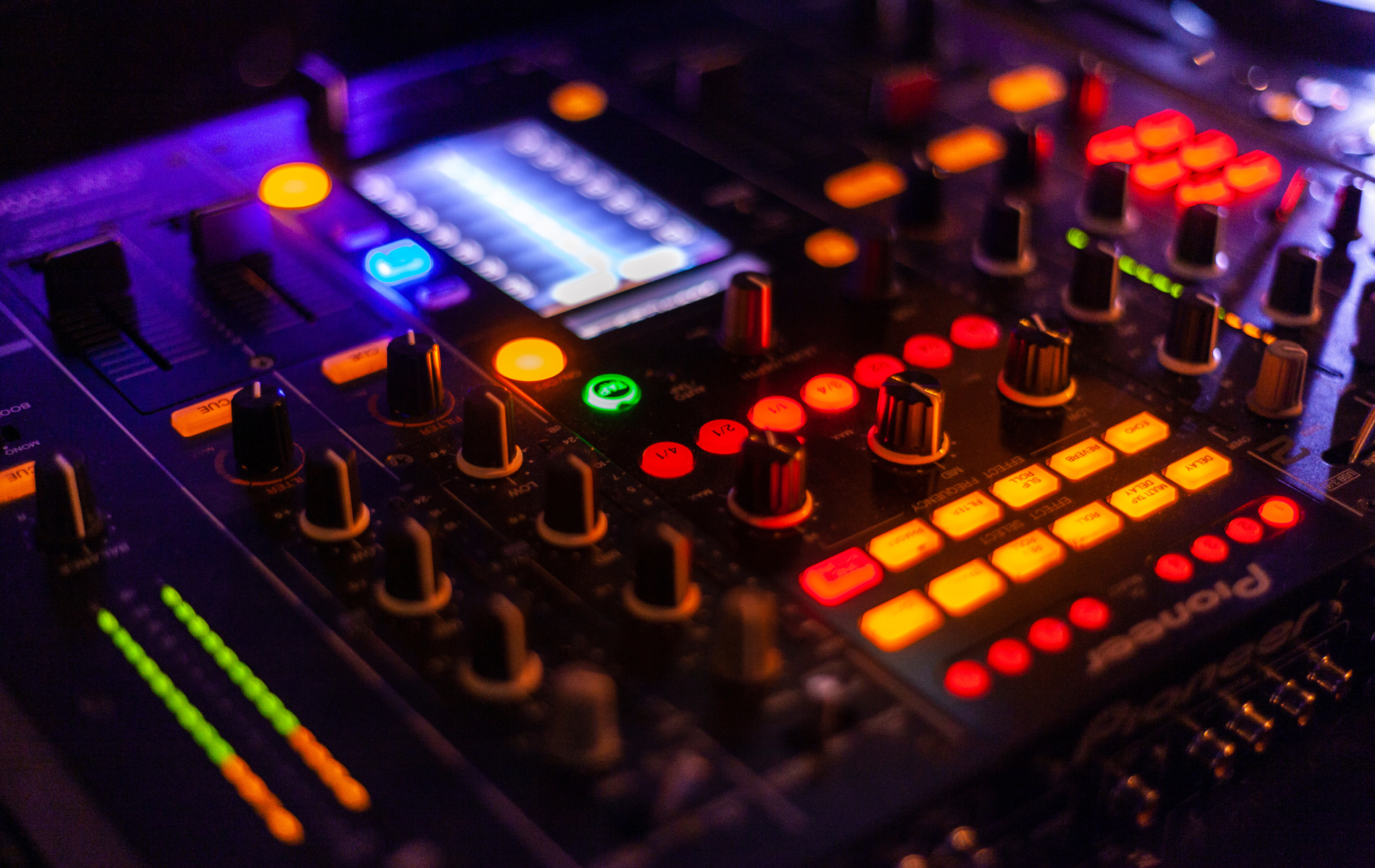 Mechanic working under a car, wearing gloves and glasses. Garage setting.