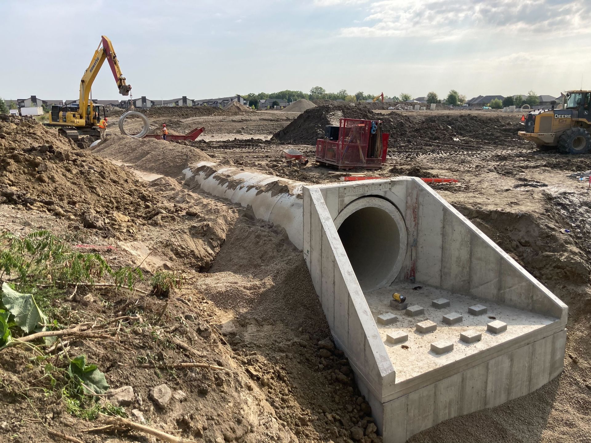 A large concrete pipe is being built in a dirt field.