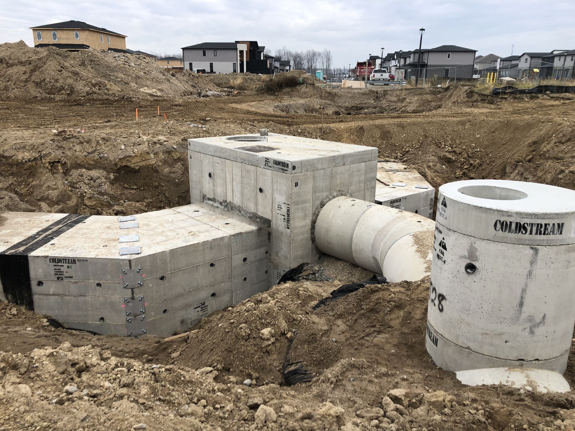 A large concrete structure is sitting in the middle of a dirt field.