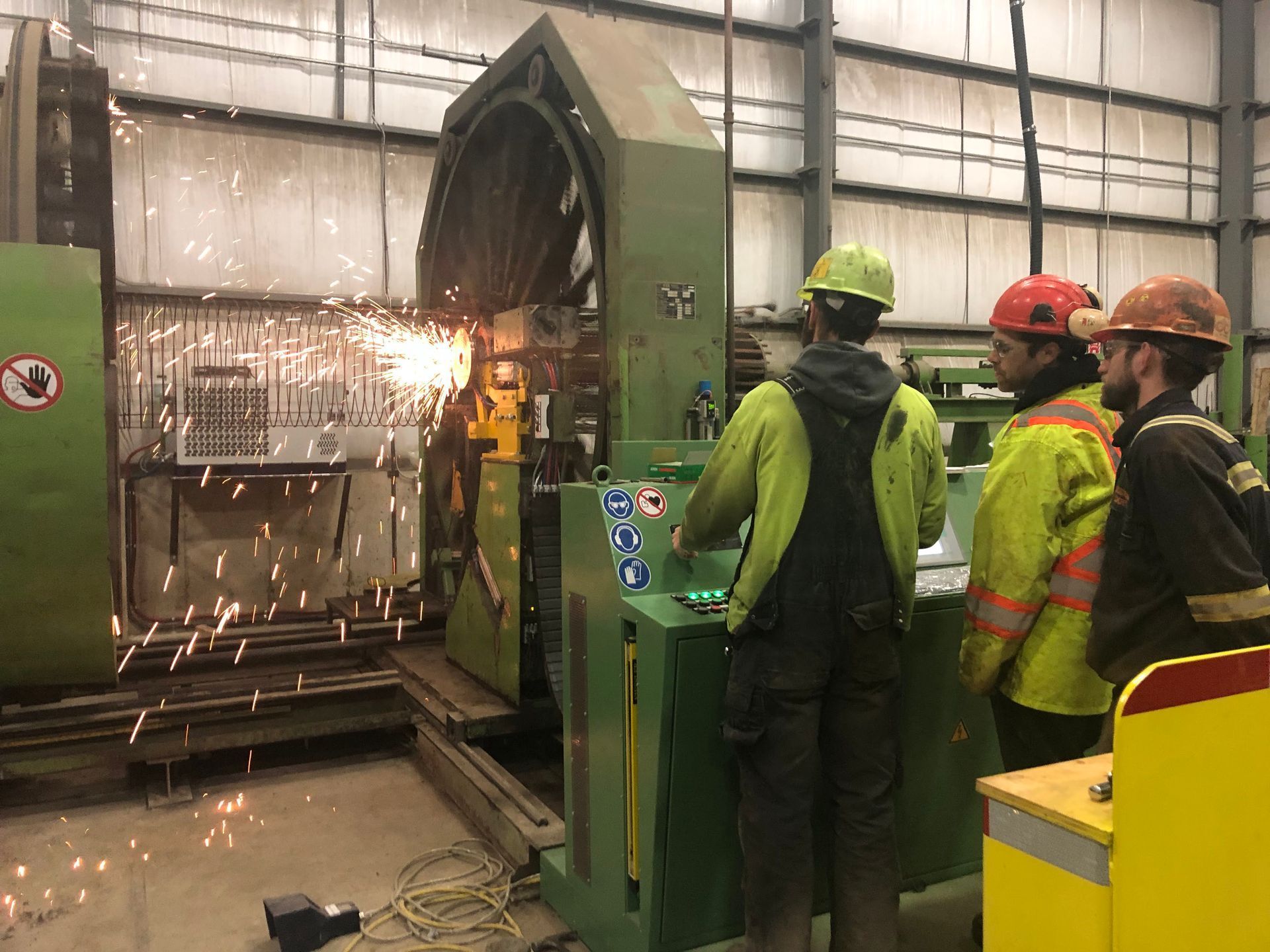 A group of men are working on a machine in a factory.
