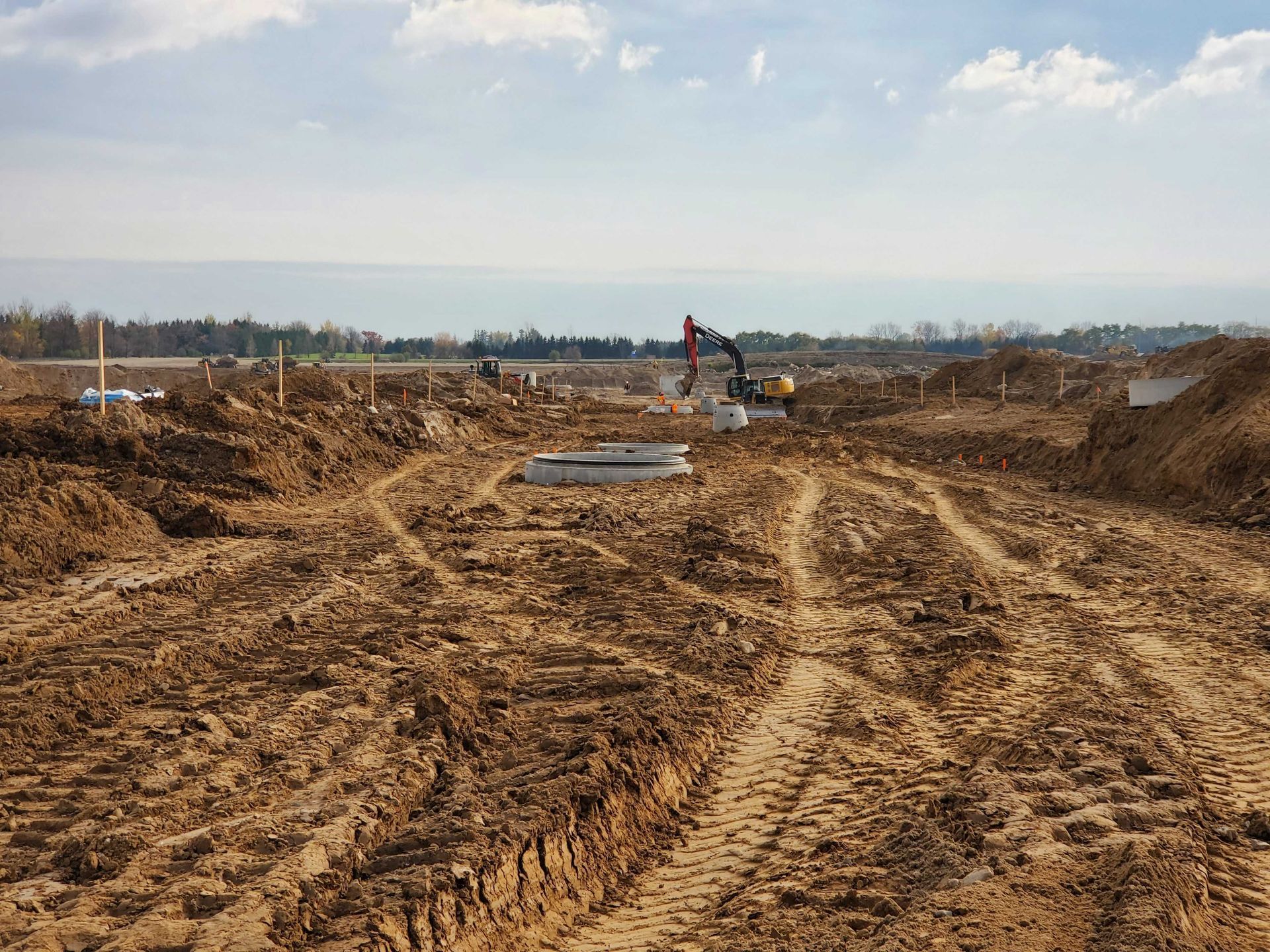 A construction site with a lot of dirt and a tractor in the background.