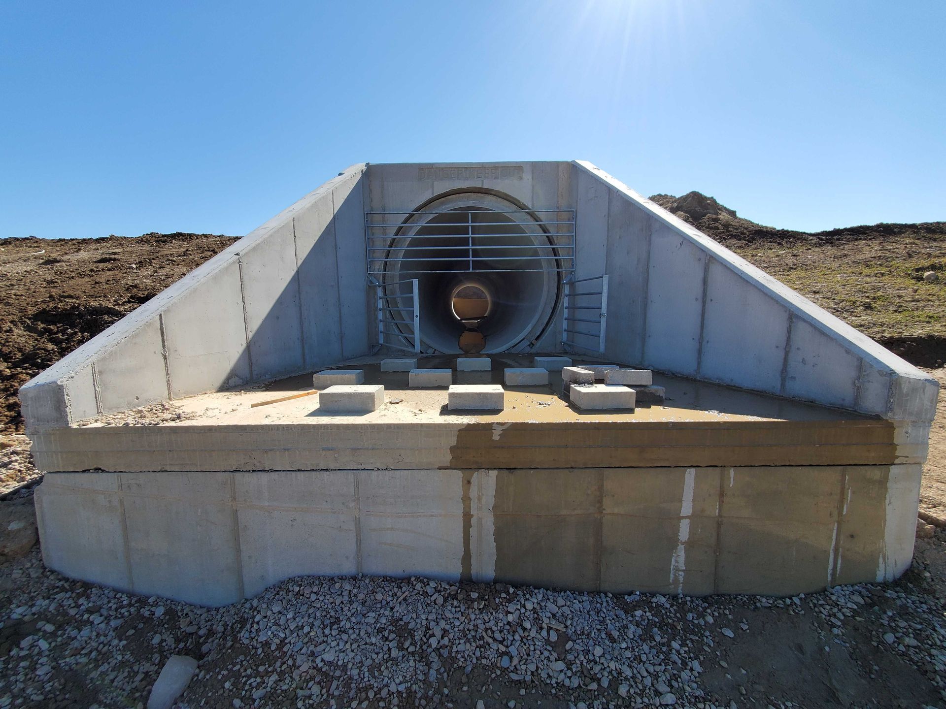 A concrete structure with a pipe going through it