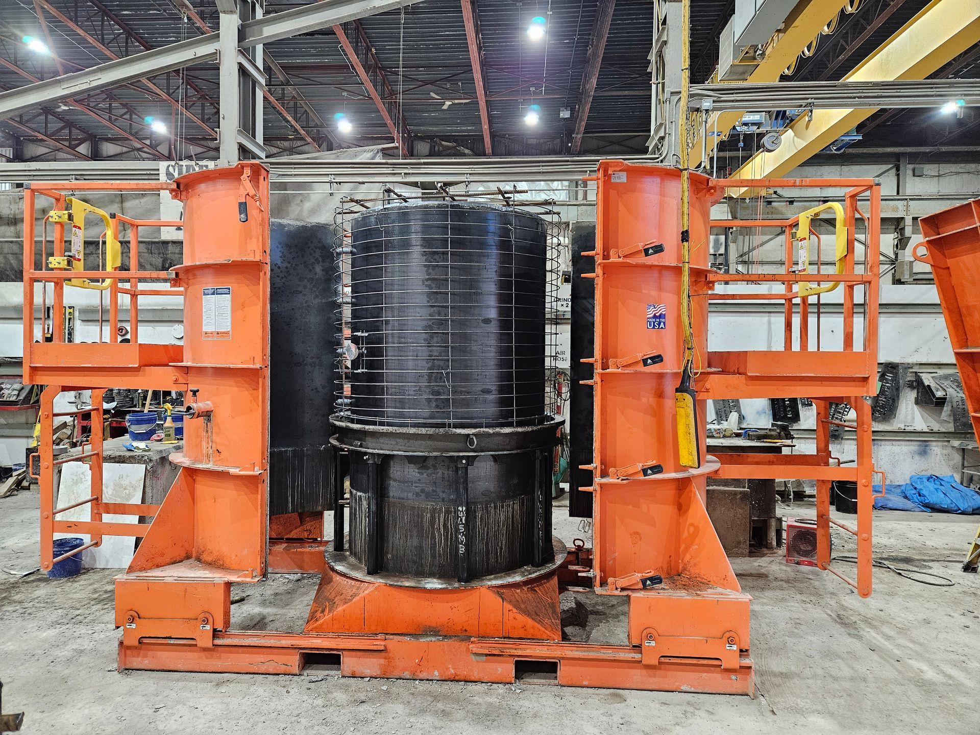 A large orange machine is sitting in a warehouse.