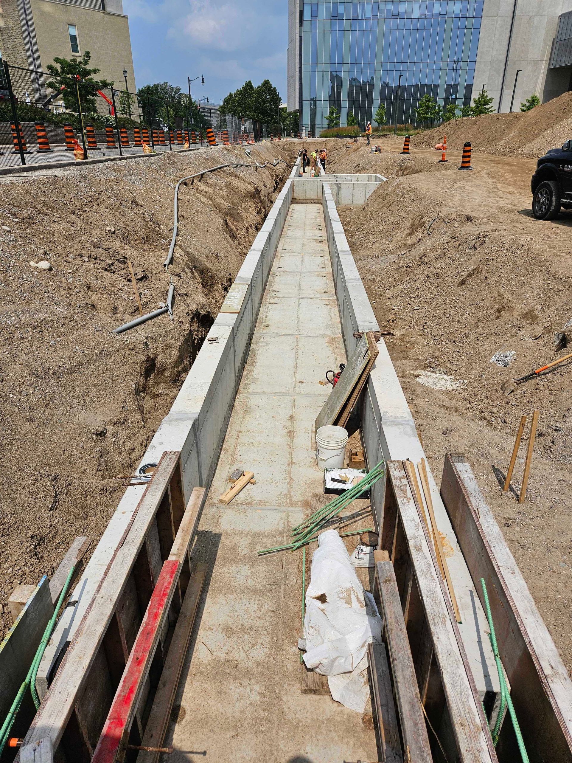 A concrete walkway is being built in a construction site.