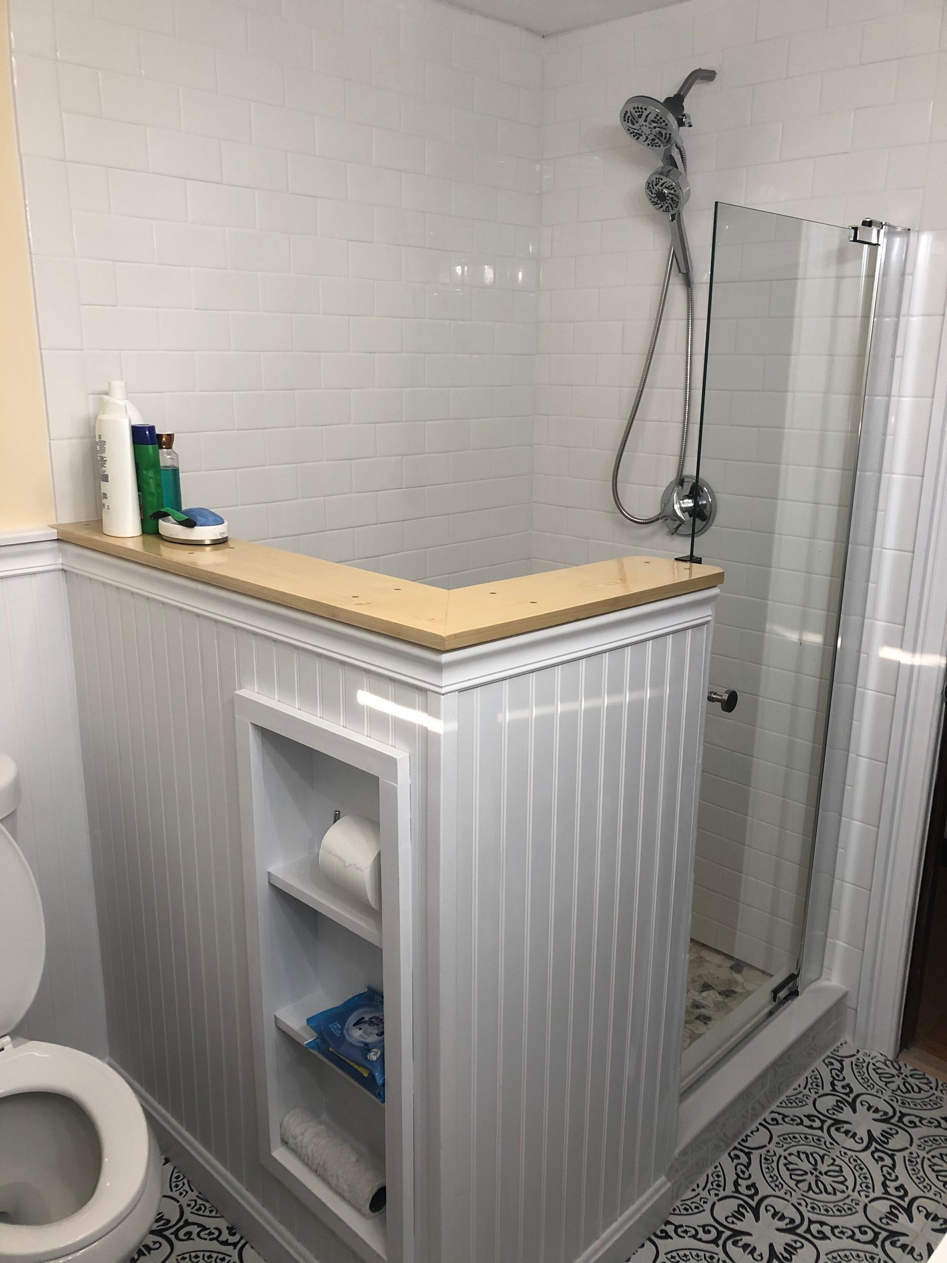 A bathroom with a toilet and a walk in shower