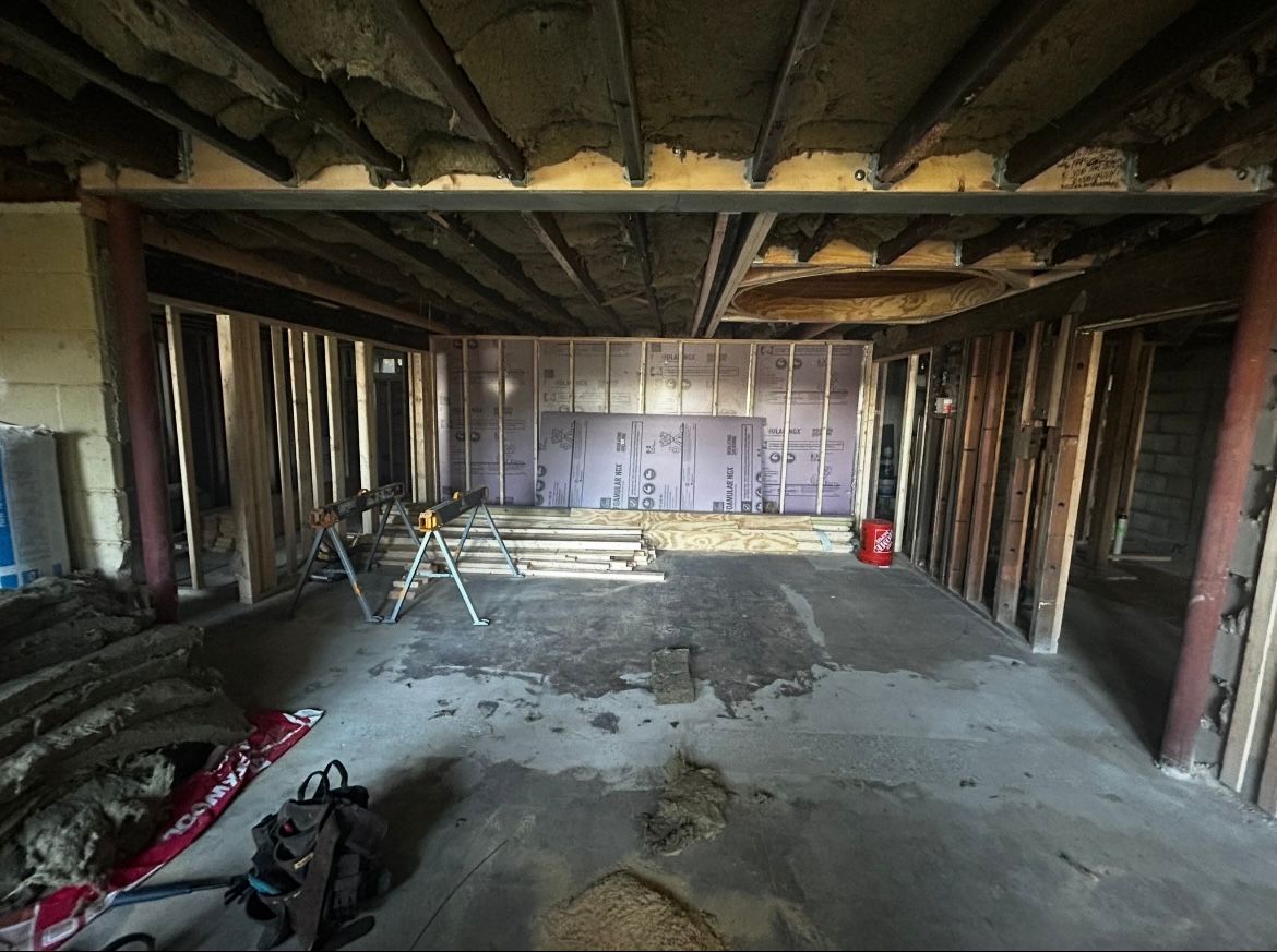 An empty room with a vacuum cleaner in the middle of it.