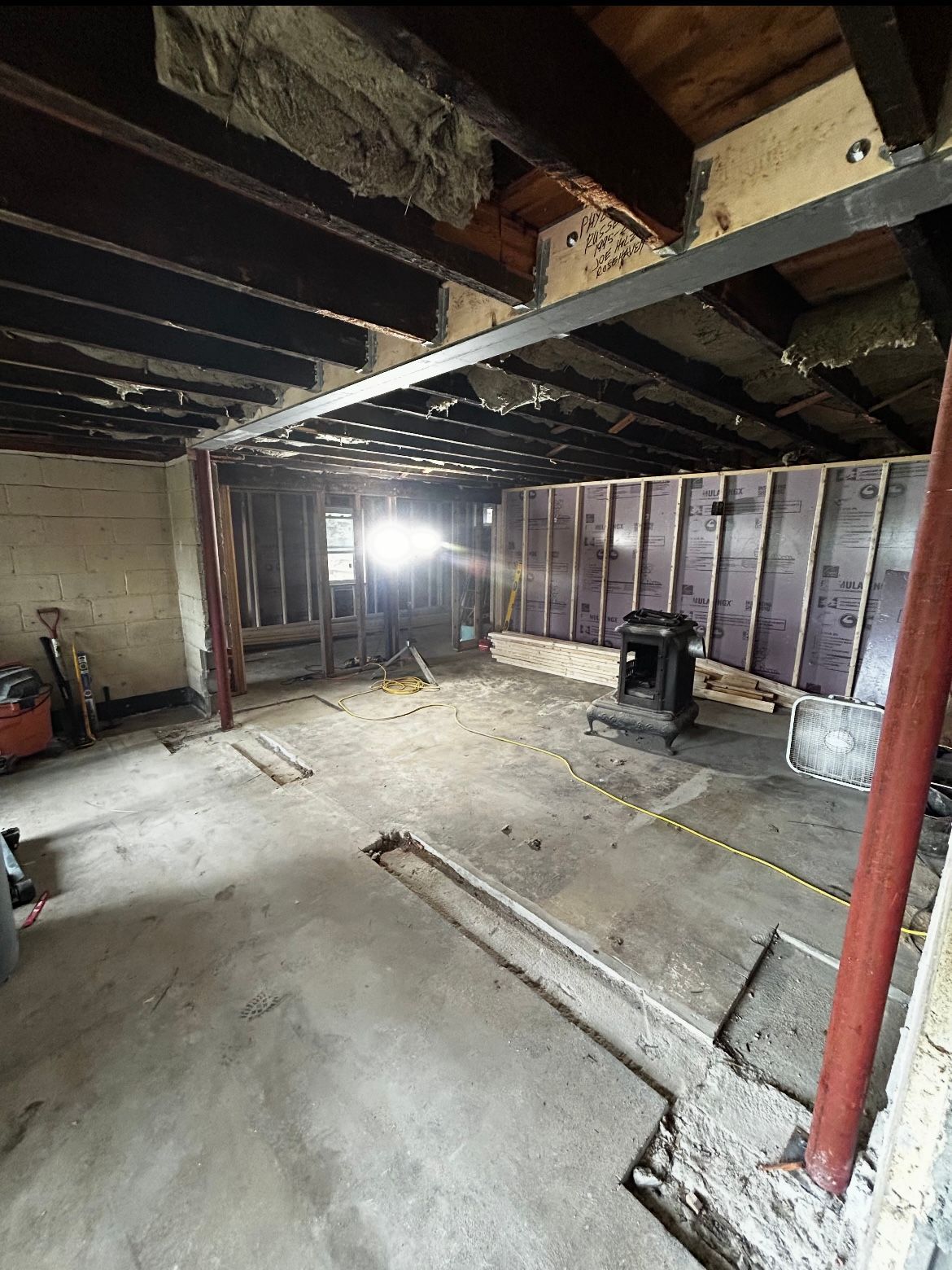 A large room with a lot of wooden beams and a concrete floor.