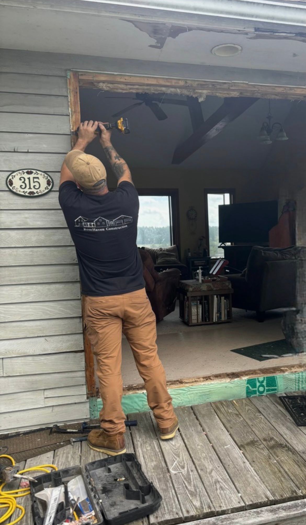A man is fixing a door on a house.