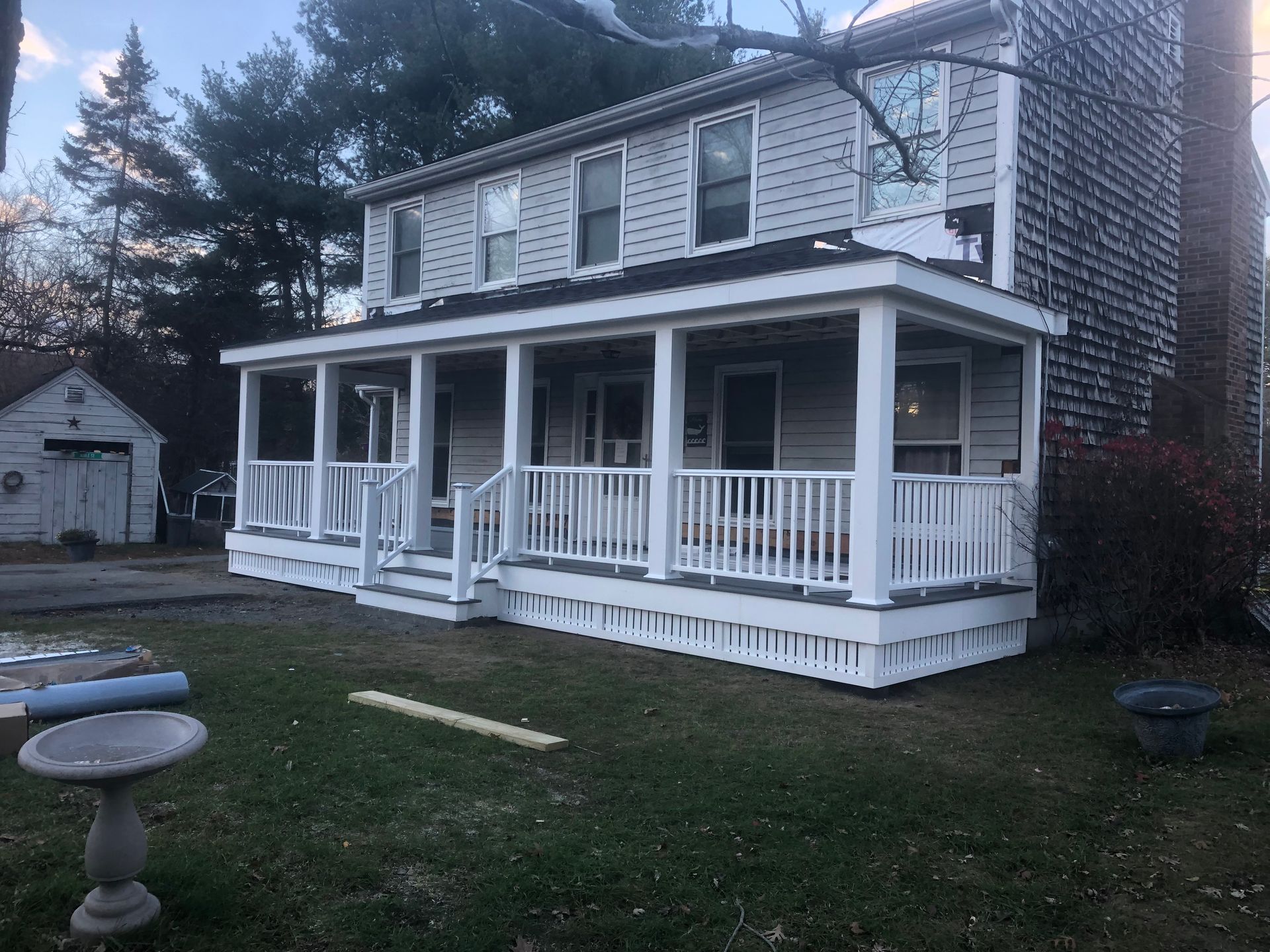 A house with a large porch and stairs is being remodeled.