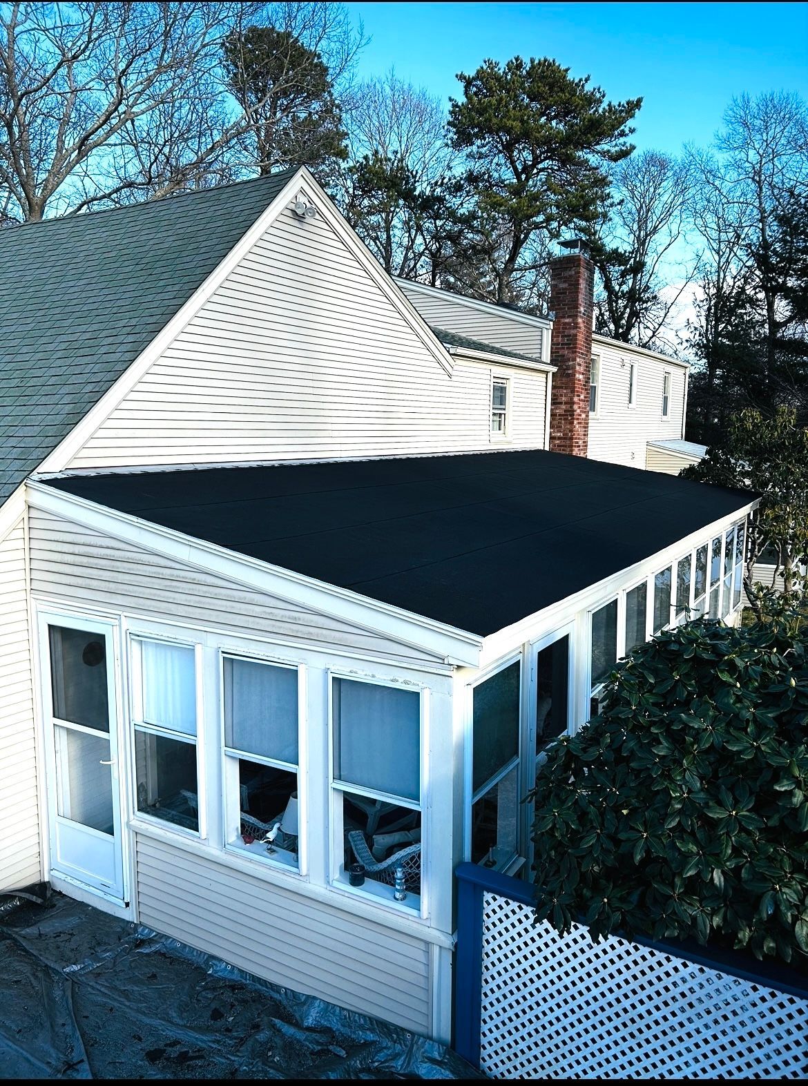 An aerial view of a white house with a black roof