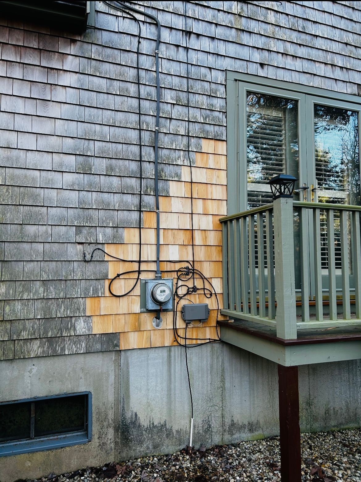 A house with a balcony and a meter on the side