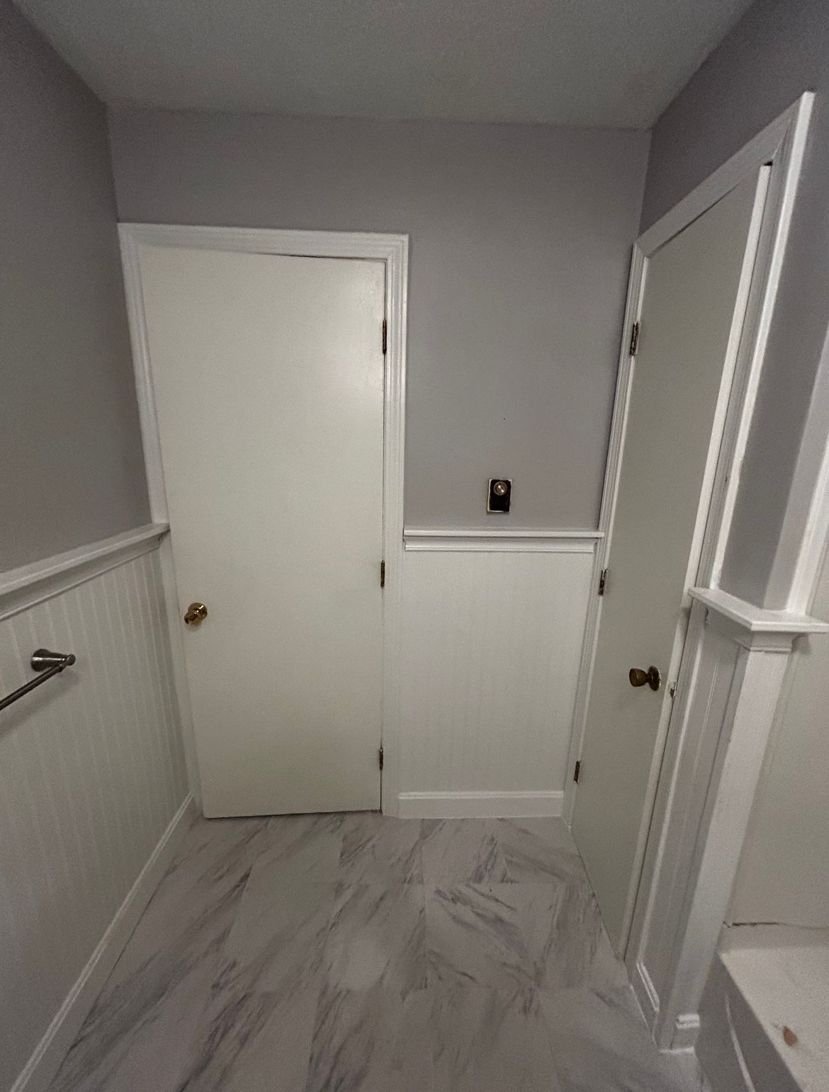 A bathroom with a toilet , sink , and door.