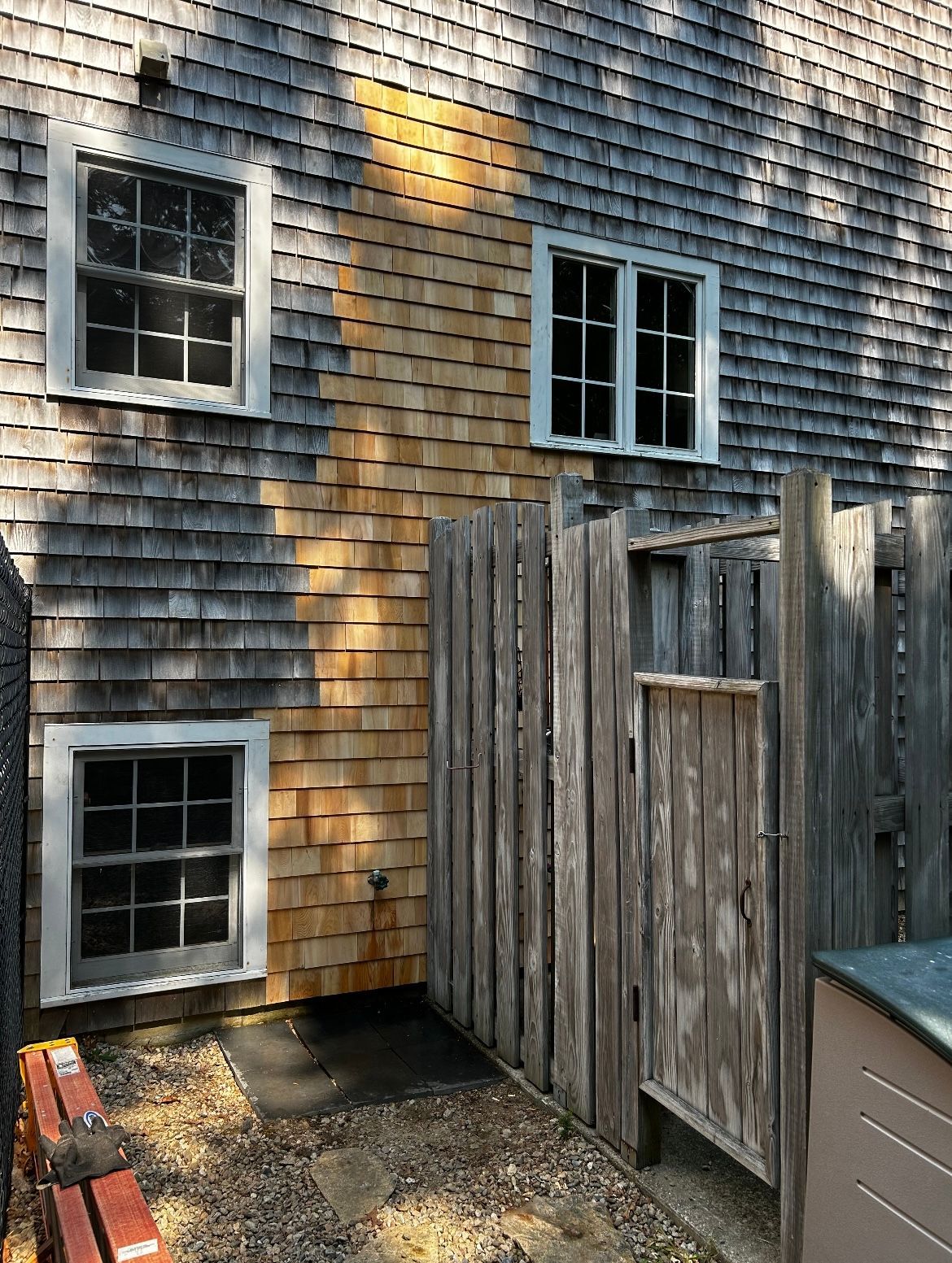 There is a wooden fence in front of a house.