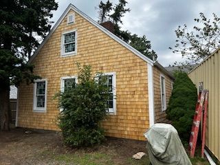 A yellow house with a ladder in front of it
