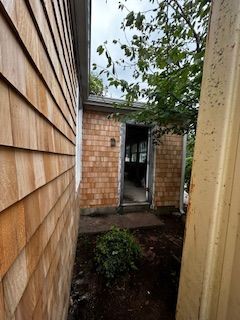 A house with a wooden siding and a door that is open.