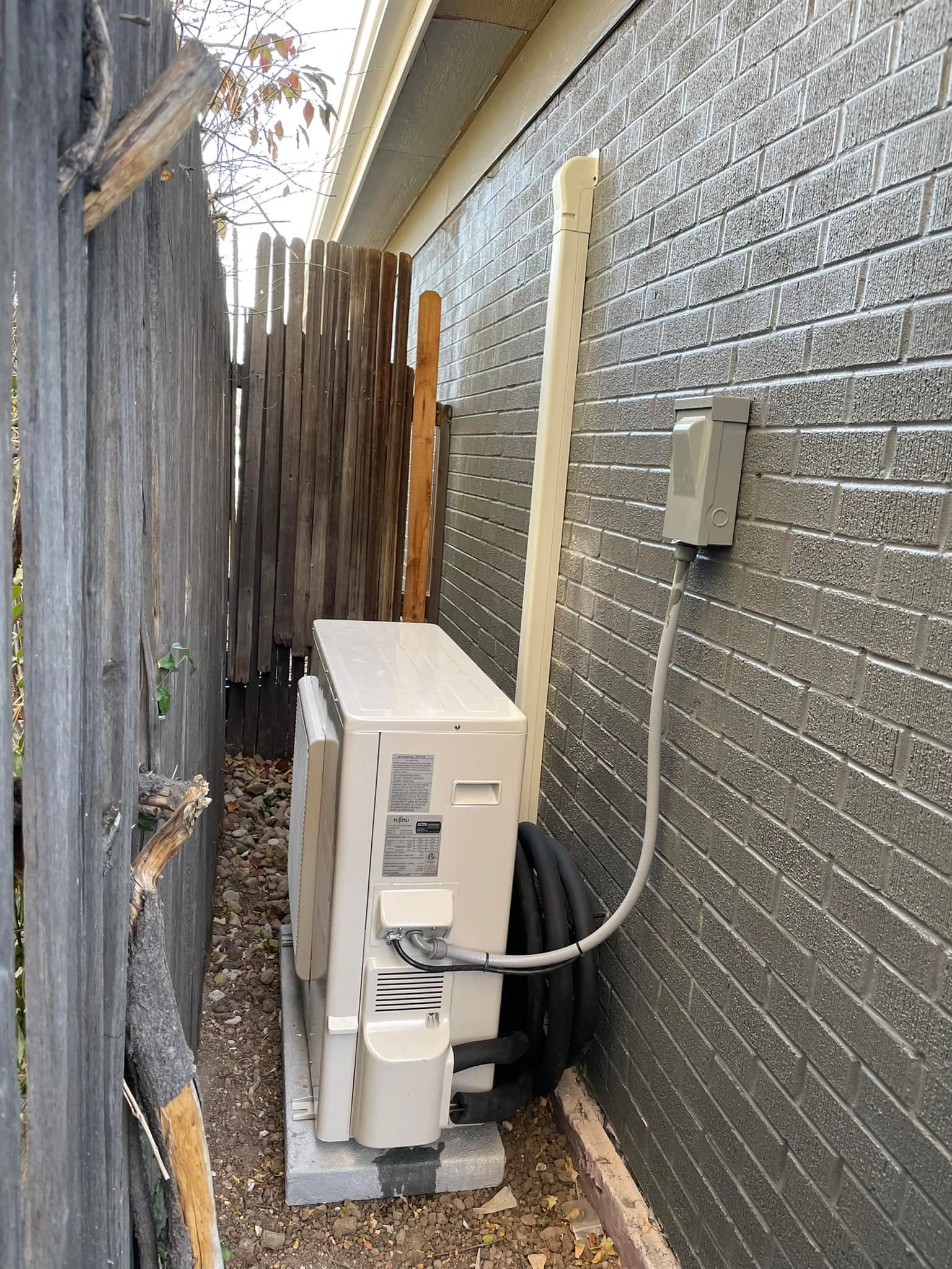 White wall-mounted air conditioner unit next to a white ceiling light.