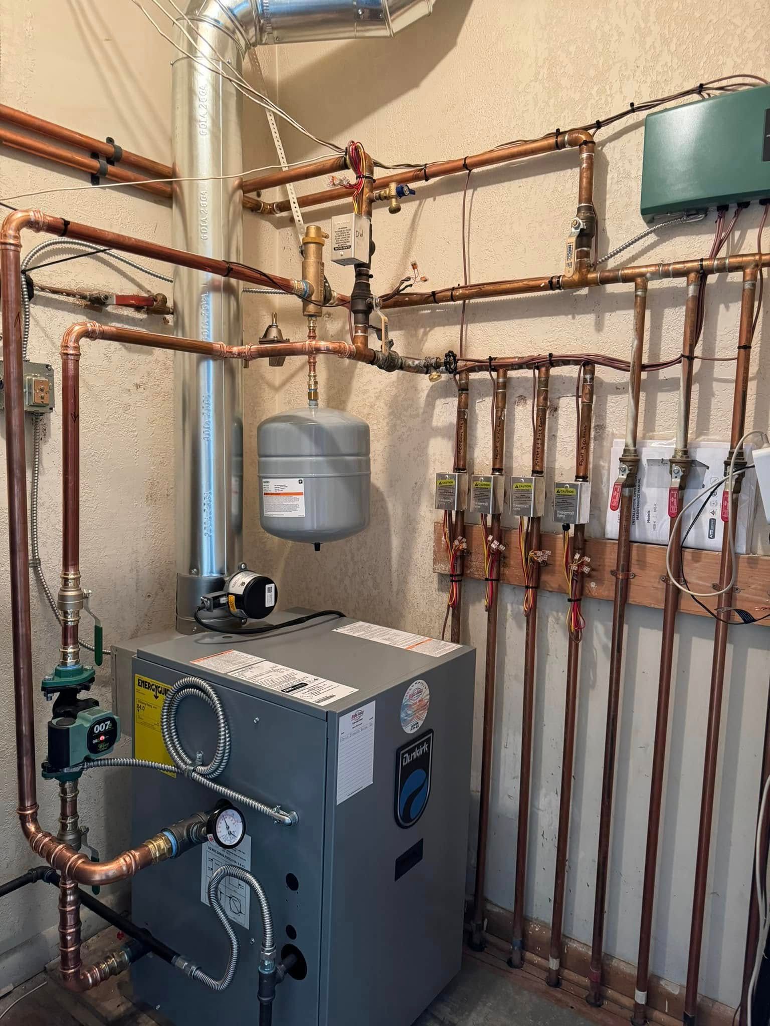 Copper pipes and heating system components mounted on a wall.