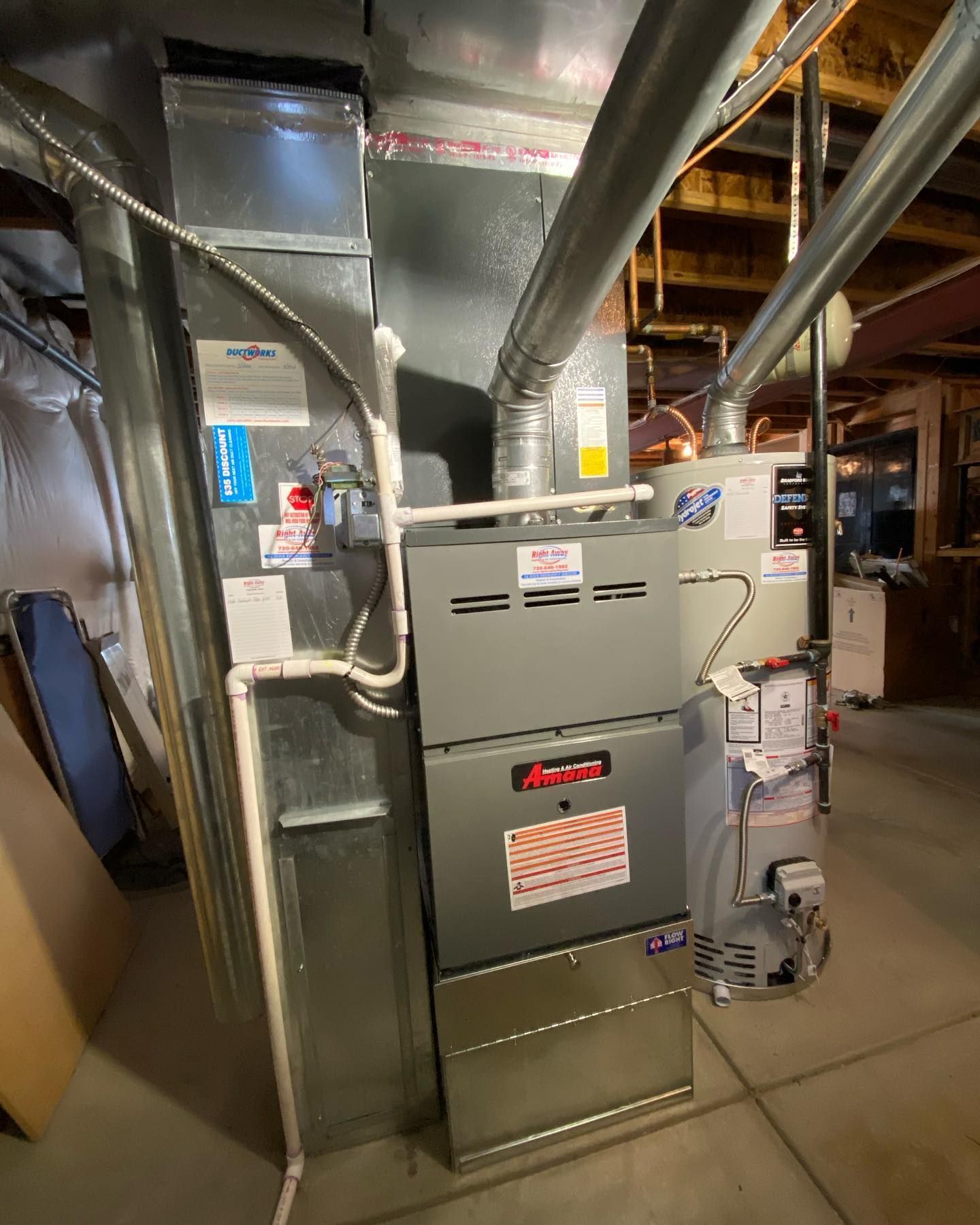 White radiator below a window next to a bed in a room.