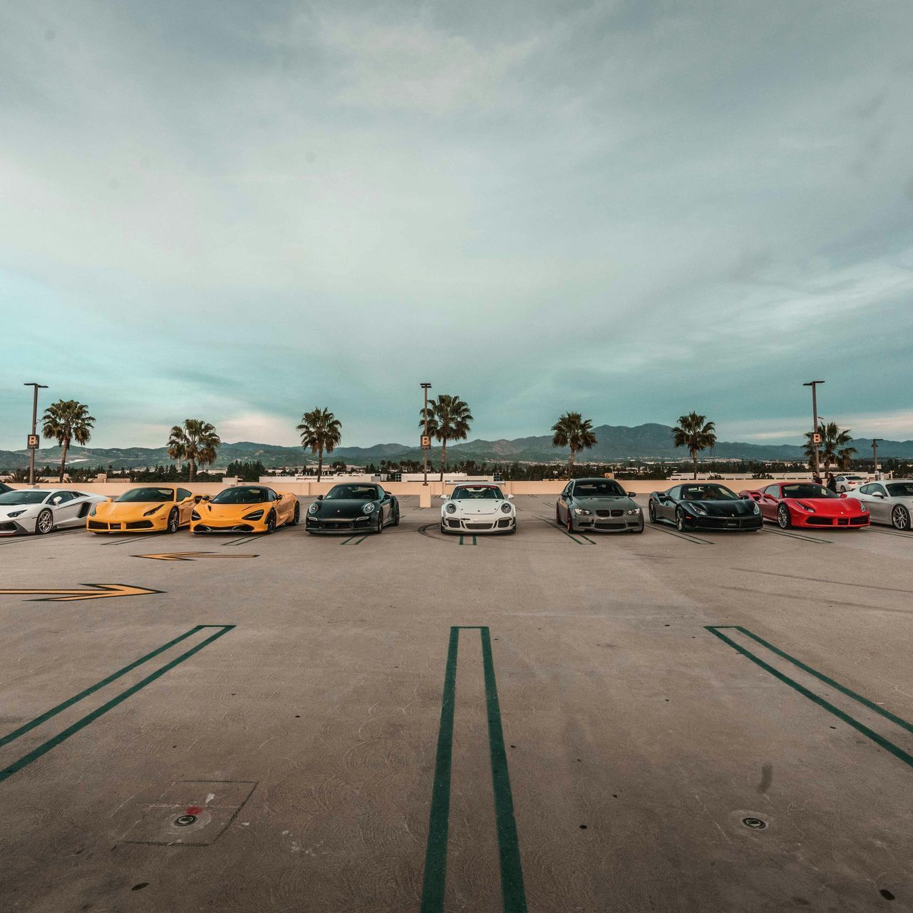 A row of cars are parked in a parking lot.