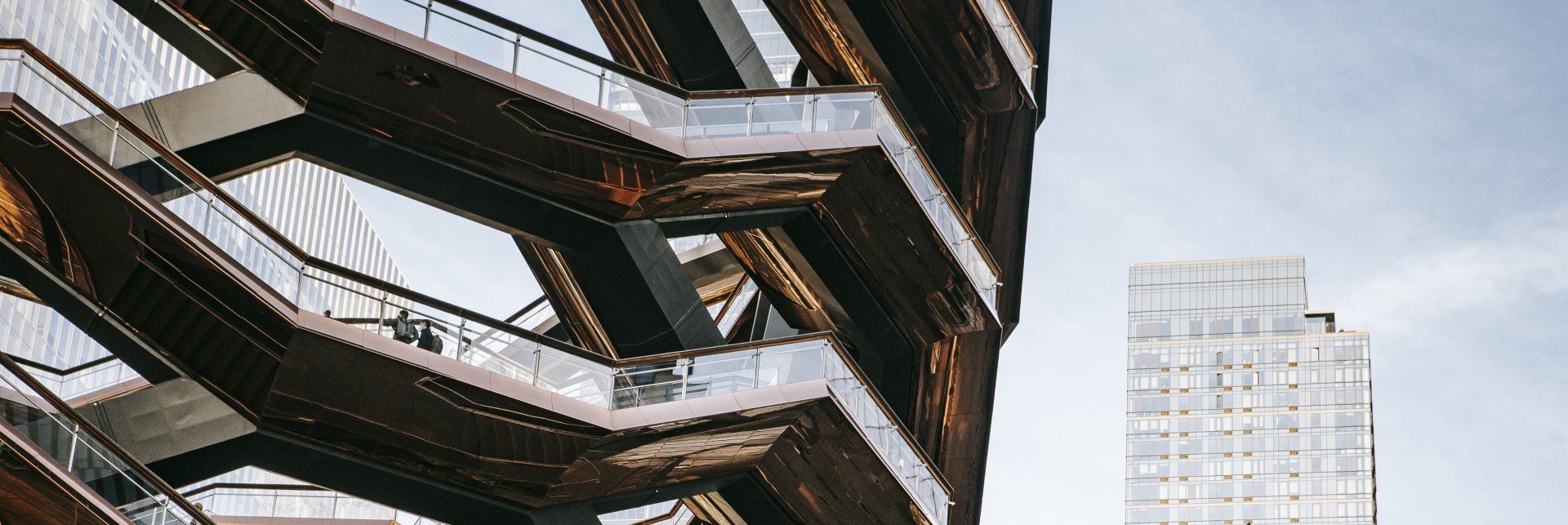 A close up of a building with stairs and a skyscraper in the background. Shows the need for facility maintenance. 