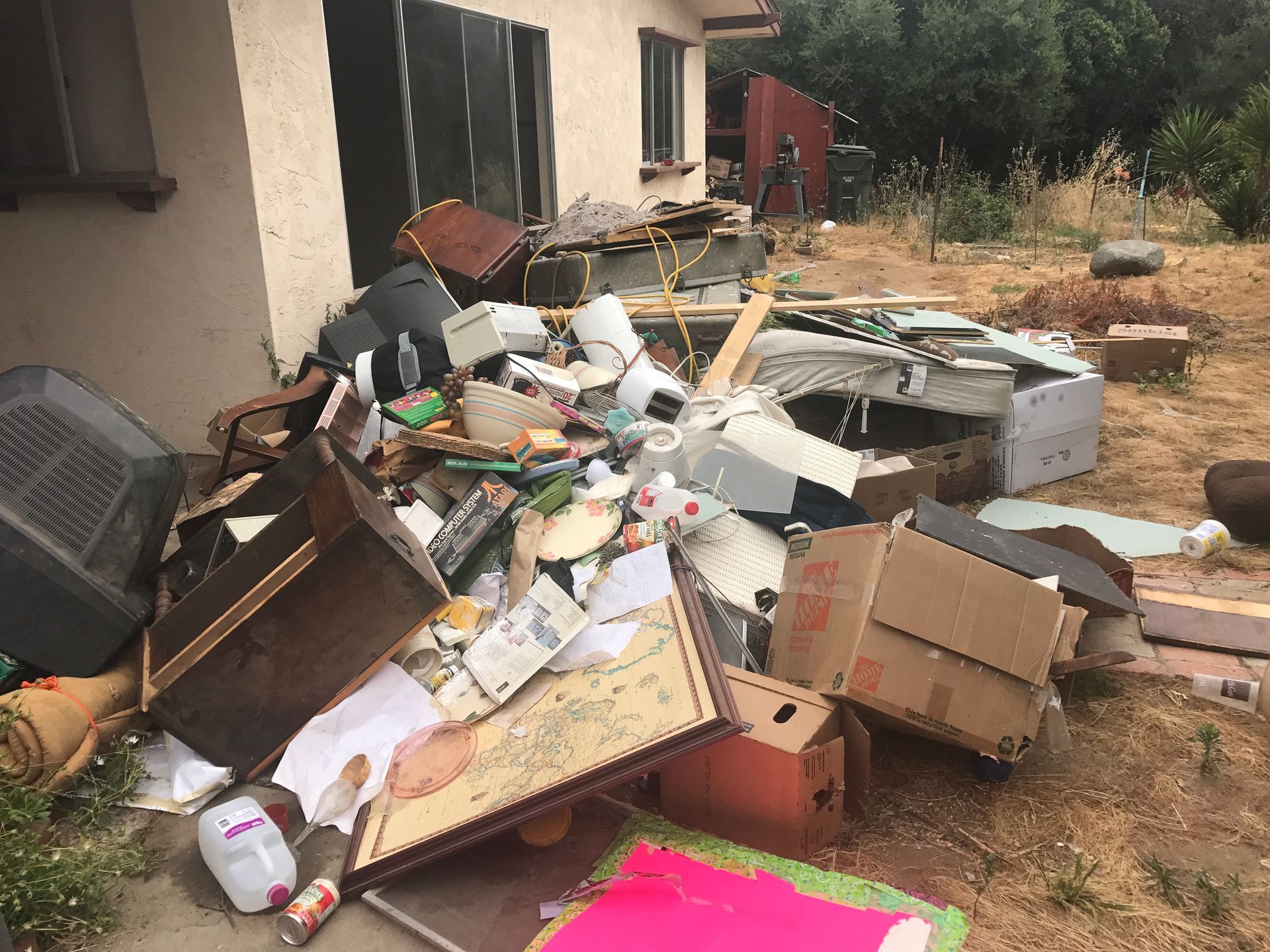 a man is carrying a bag of trash next to a garbage truck .