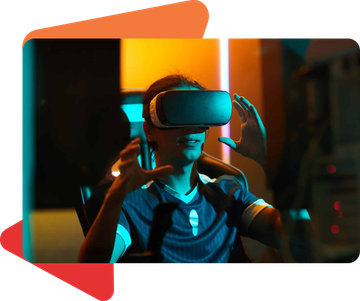 A person wearing a VR headset, gesturing with both hands in a dimly lit, blue and orange-toned room.
