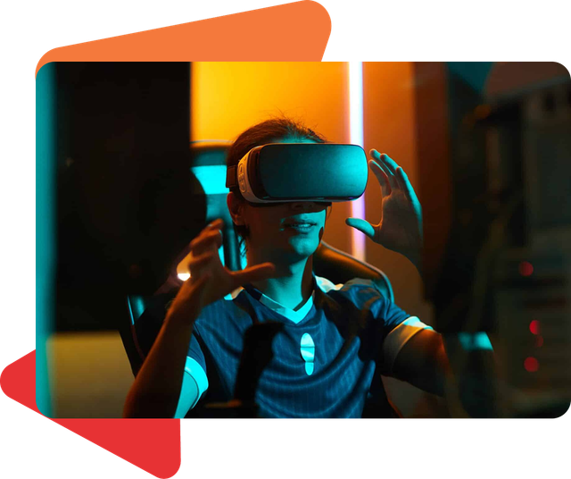 A person wearing a VR headset, gesturing with both hands in a dimly lit, blue and orange-toned room.