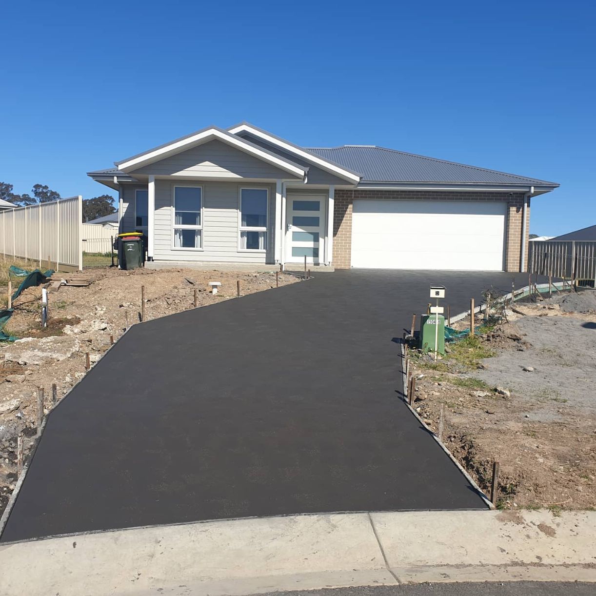 A Driveway Leading to A House with A White Garage Door — Turn It Crete in Nowra, NSW