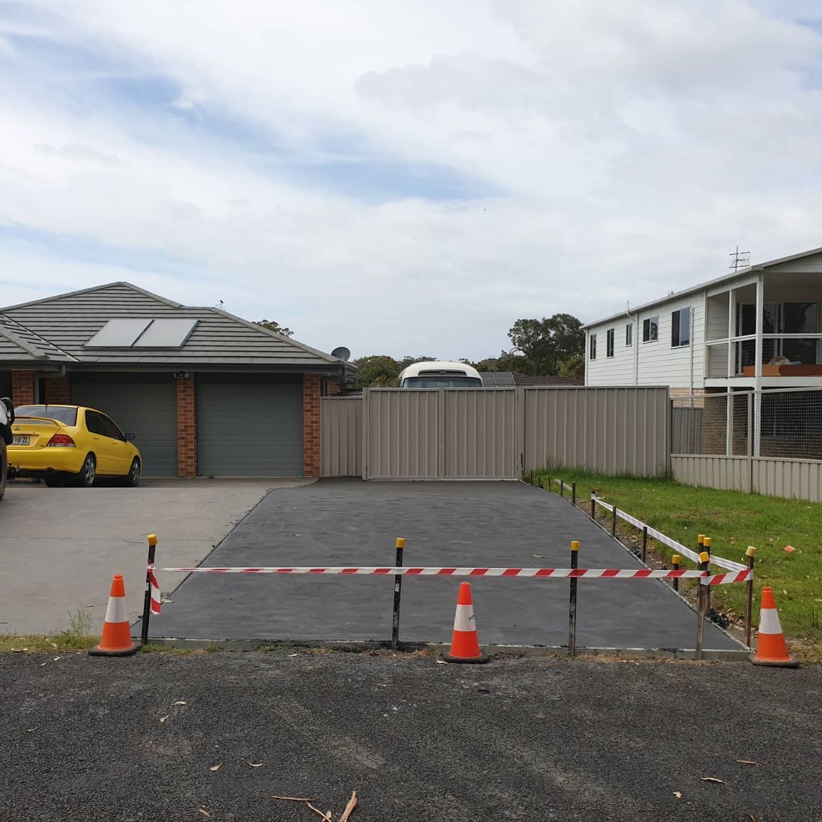 A Yellow Car Is Parked in The Driveway of A House — Turn It Crete in Sussex Inlet, NSW