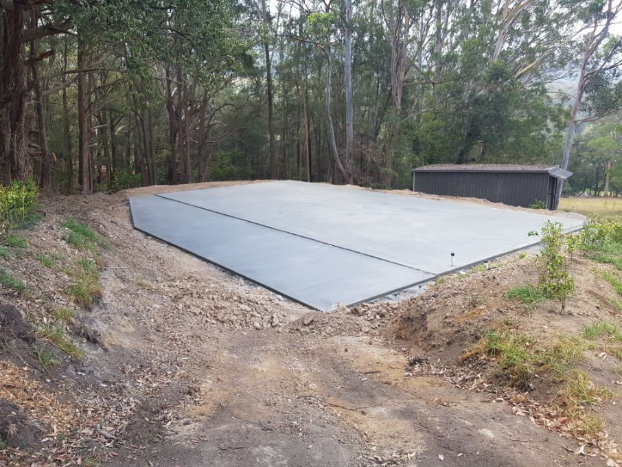 A Large Concrete Slab Is Sitting On Top Of A Dirt Hill In The Middle Of A Forest — Turn It Crete in St Georges Basin, NSW