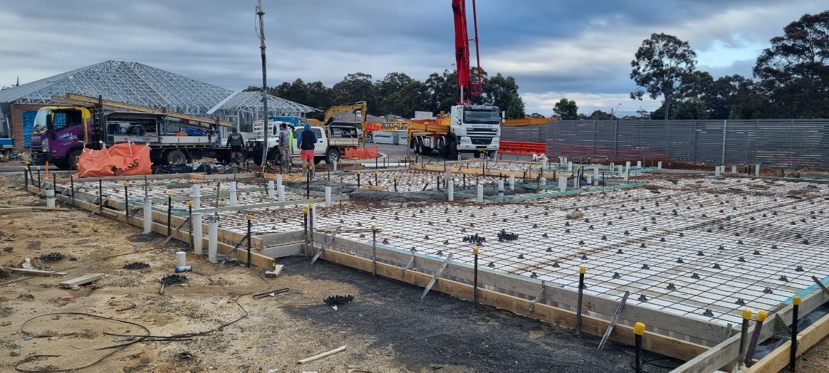 A Construction Site With A Crane Pumping Concrete Into The Ground — Turn It Crete in St Georges Basin, NSW