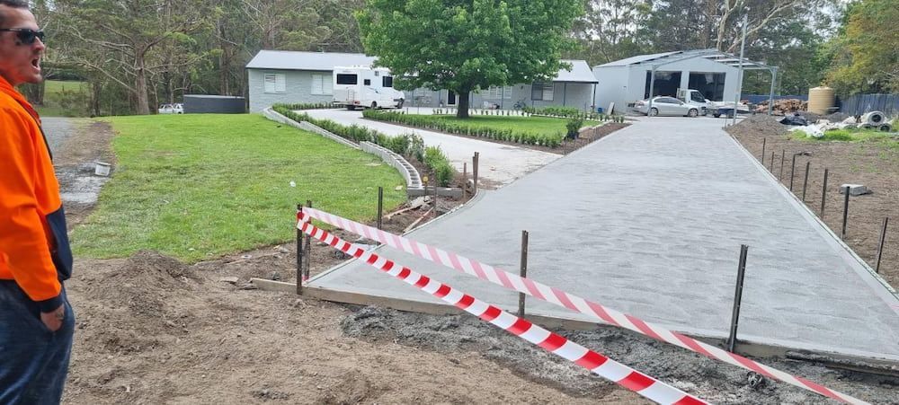 A Man Is Standing In Front Of A Concrete Driveway — Turn It Crete in St Georges Basin, NSW