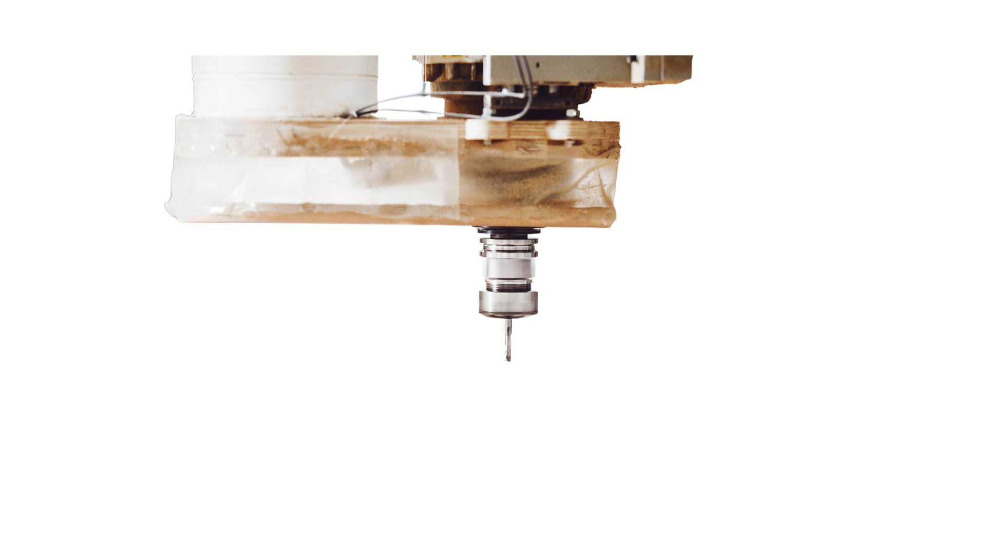 A machine is cutting a piece of wood on a white background.