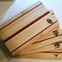 A stack of wooden cutting boards sitting on top of each other on a table.