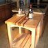 A wooden table with two bottles of wine on it in a kitchen.