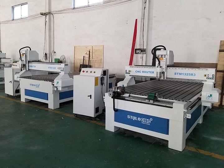 Several CNC wood carving machines in a workshop, white and blue.