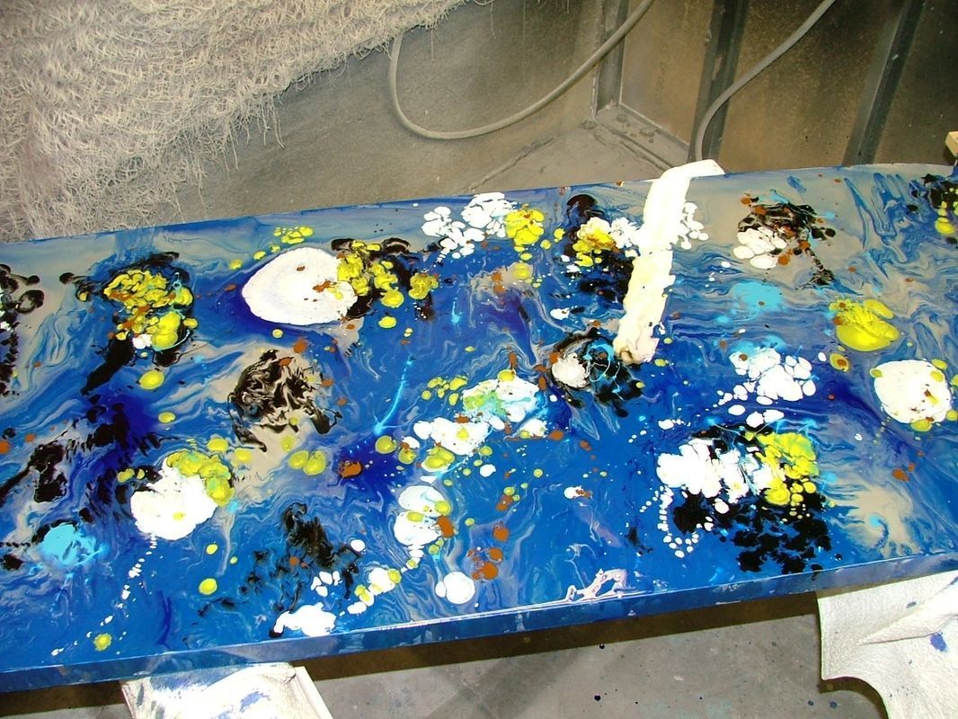 A blue table with a lot of paint on it