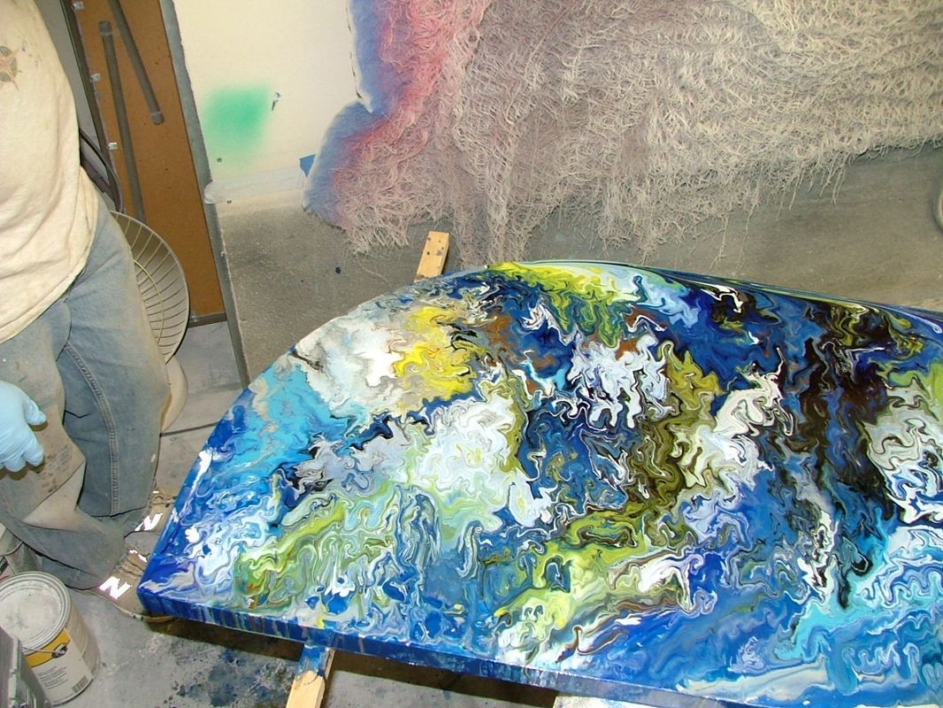A person is standing next to a table with a painting on it.