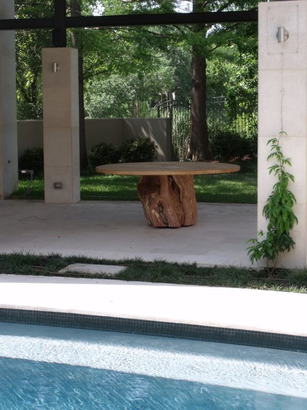A large wooden table sits next to a swimming pool
