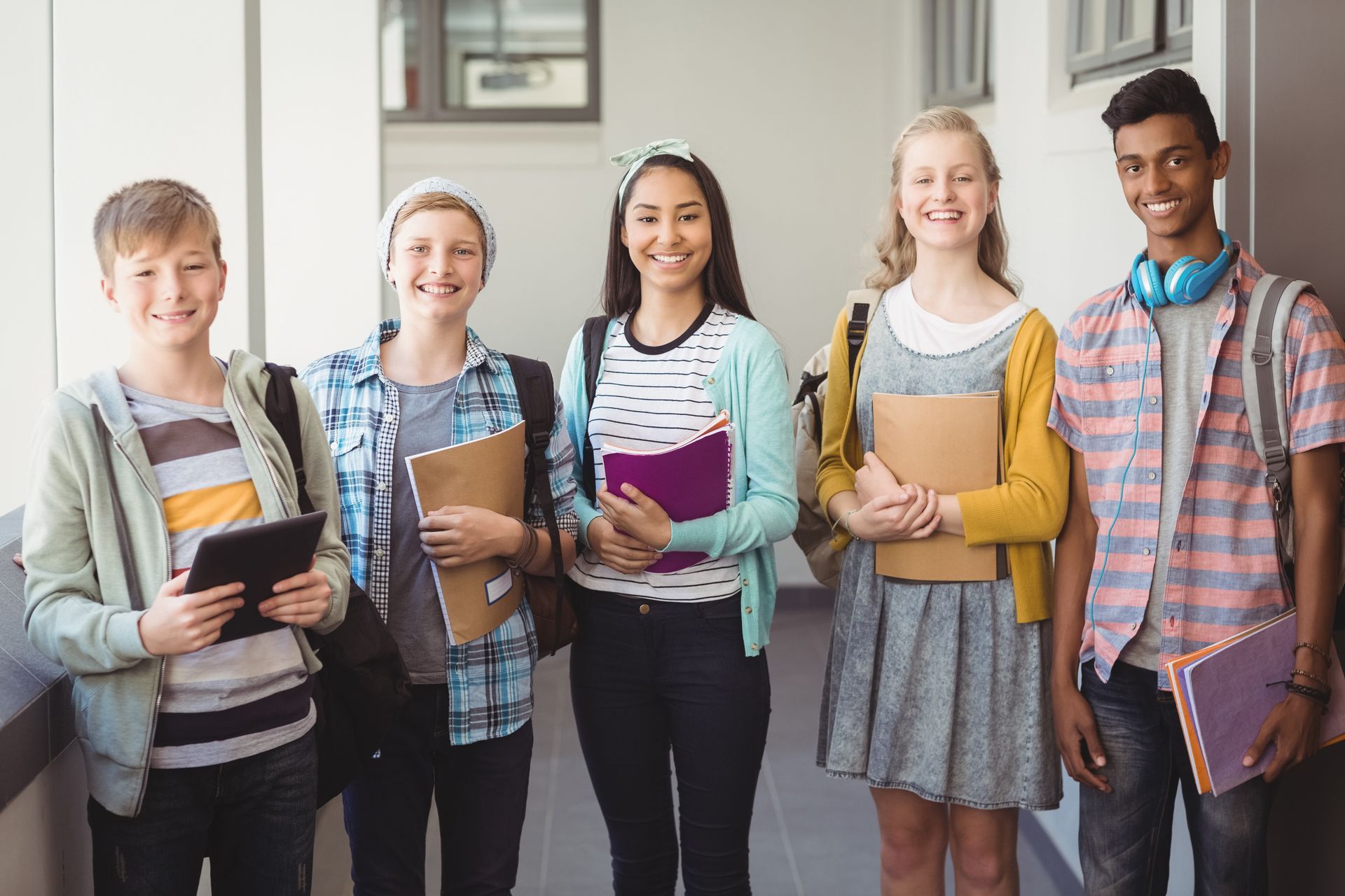 A group of students are posing for a picture in a hallway.