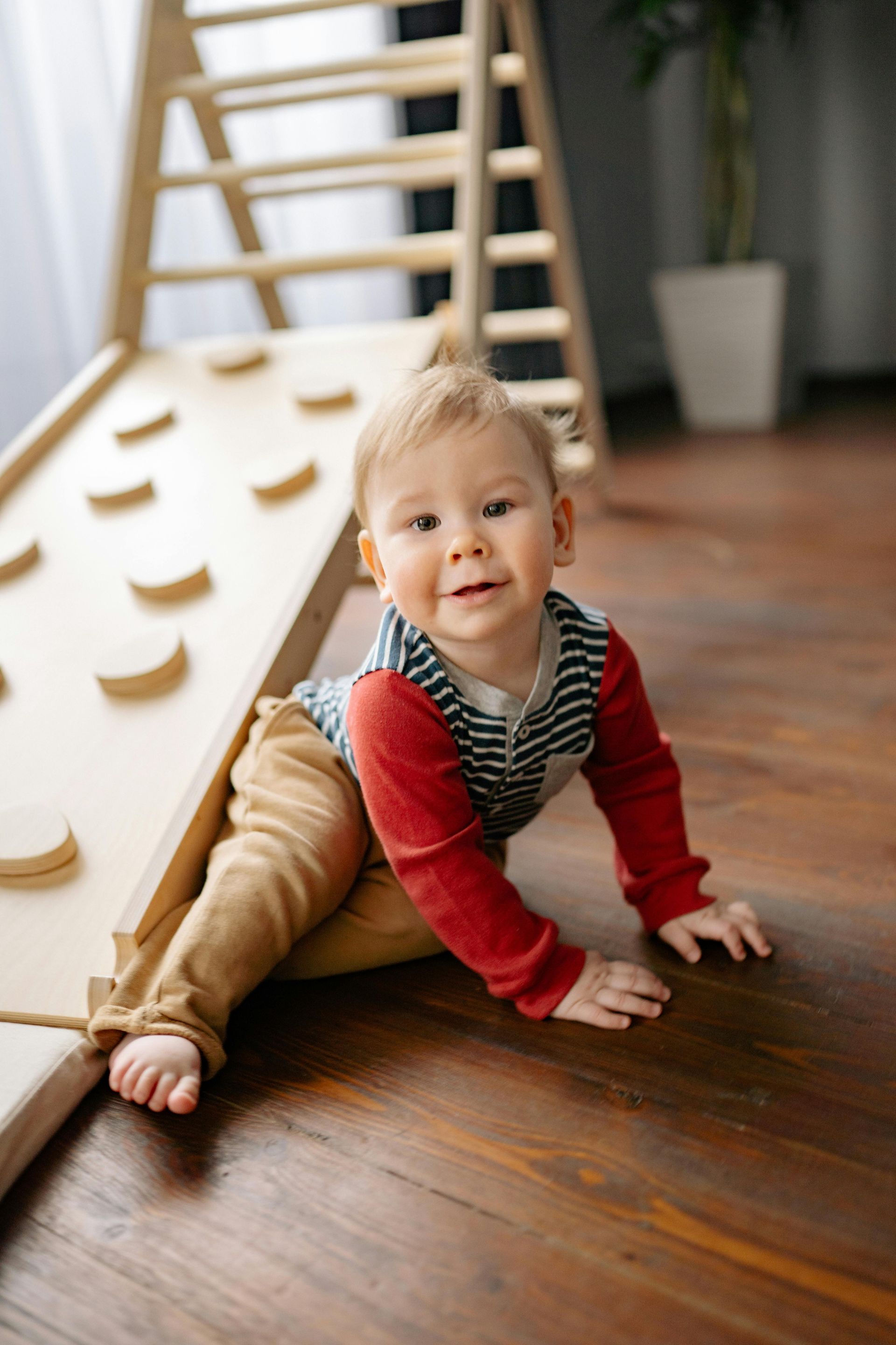 Smiling toddler in red and blue shirt, brown pants at Play's Kool Floreat Childcare Centre.