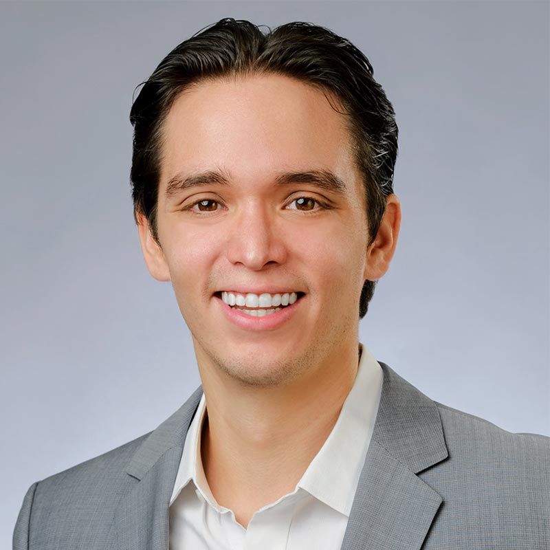 A man in a suit and white shirt is smiling for the camera
