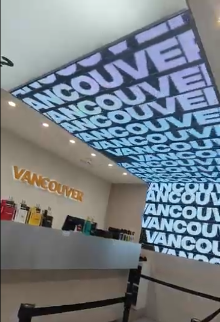 Interior de una tienda en Vancouver con techo iluminado y señalización.