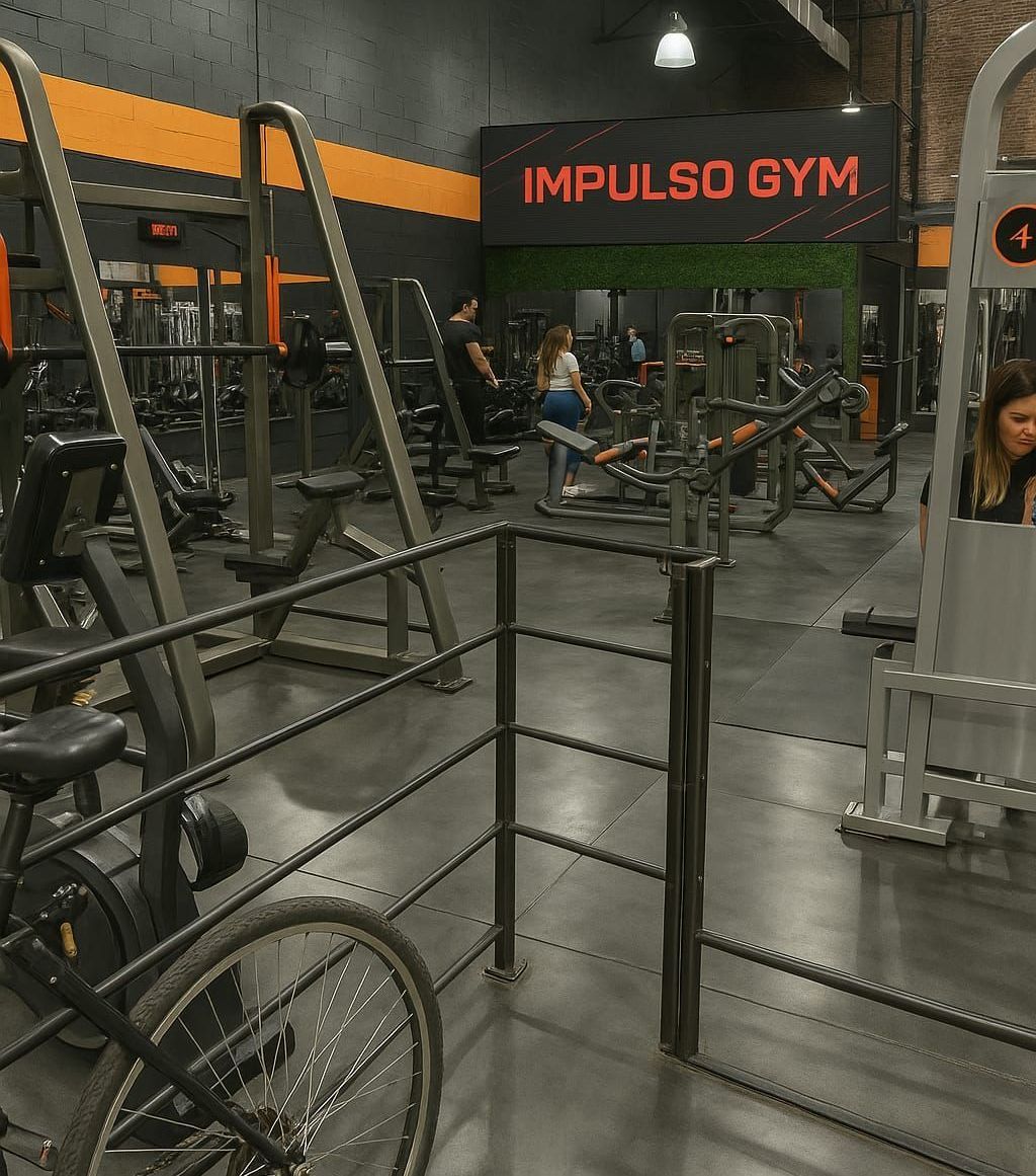 Interior de gimnasio con máquinas de ejercicio, personas y el letrero 