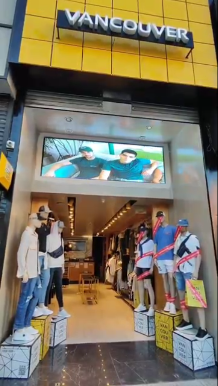 Fachada de una tienda de ropa en Vancouver; maniquíes con los brazos vendados con cinta adhesiva están de pie sobre cajas. 