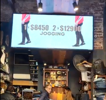 En el interior de una tienda, una pantalla muestra el precio de los conjuntos deportivos