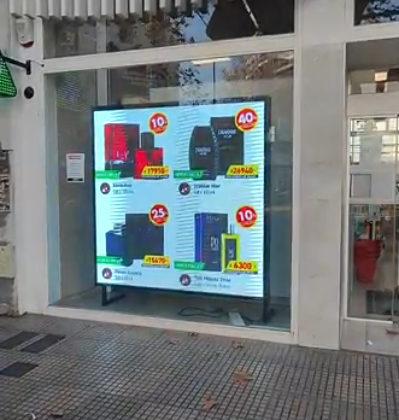 Letrero digital en el escaparate que muestra anuncios de productos con precios.