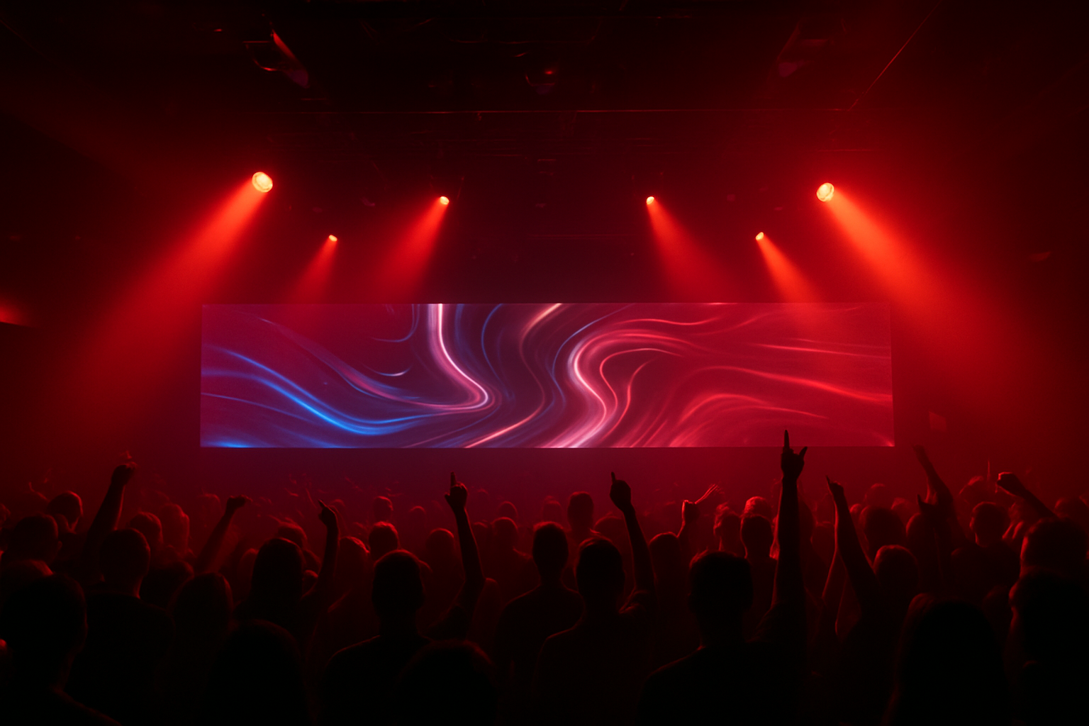 Concierto con luces rojas en el escenario que iluminan una pantalla con patrones azules 